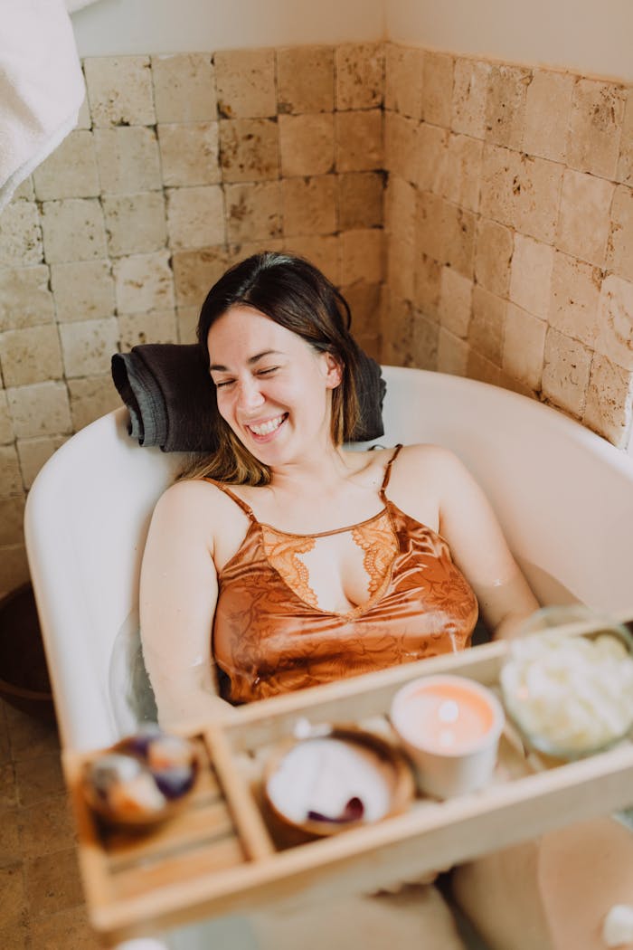 Woman enjoying a peaceful bath surrounded by spa essentials, perfect for self-care routines.